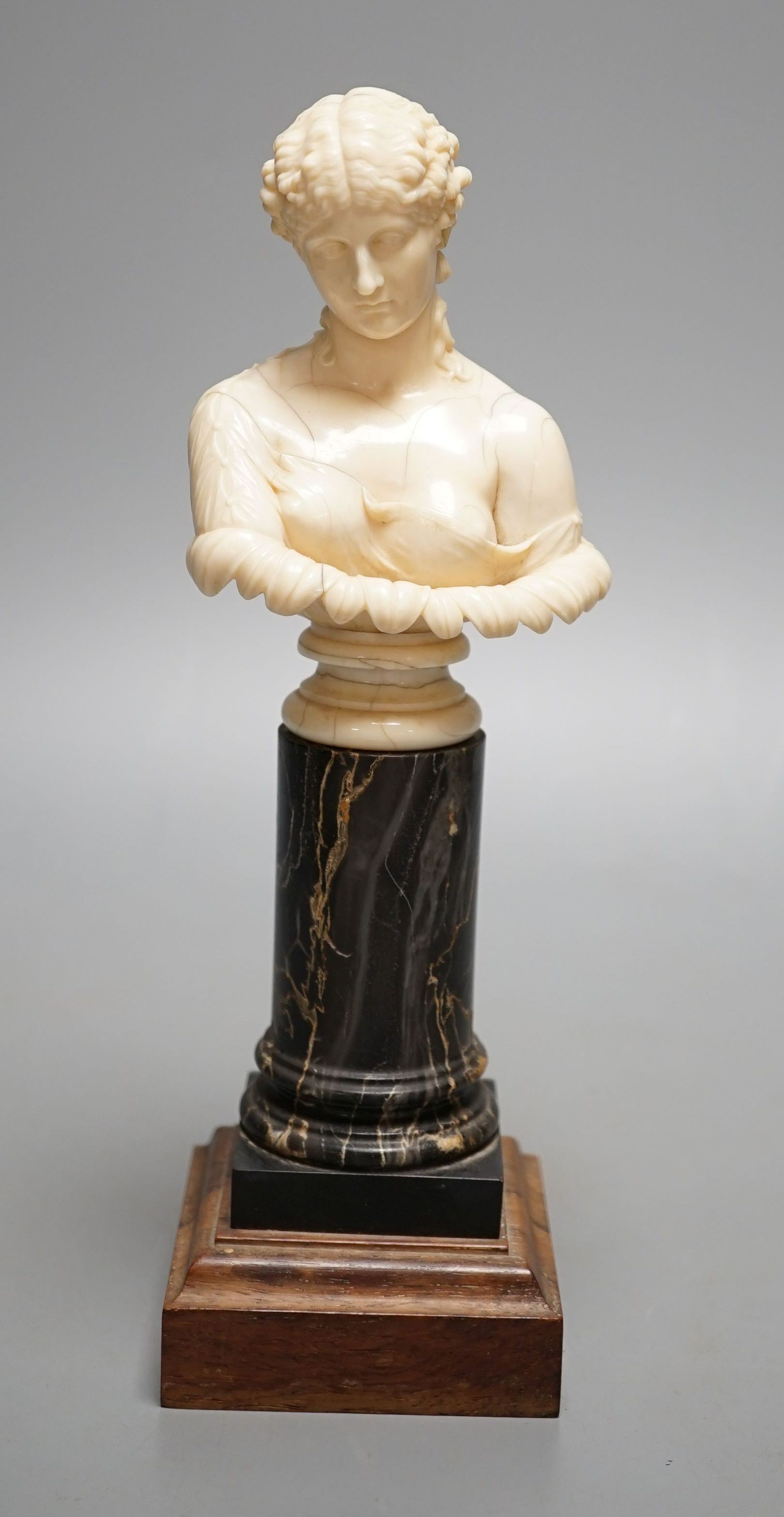 A 19th-century Dieppe ivory bust of Clytie, on a marble and rosewood pedestal, after the model in the British Museum - 24.5cm tall